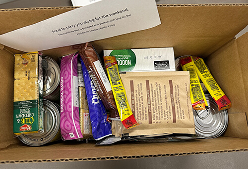Open weekend Sunshine Box meal kit filled with crackers, snacks, and canned goods
