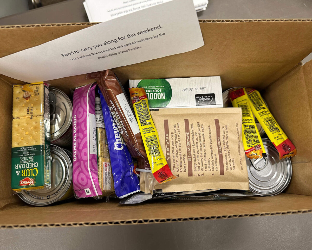 Open weekend Sunshine Box meal kit packed by Diablo Valley Giving Partners, filled with crackers, snacks, and pantry staples