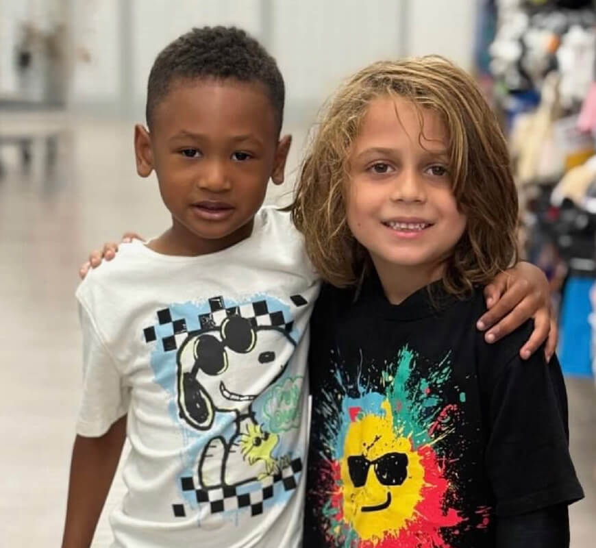 Two young boys smiling with arms around each other at the Diablo Valley Giving Partners thrift shop
