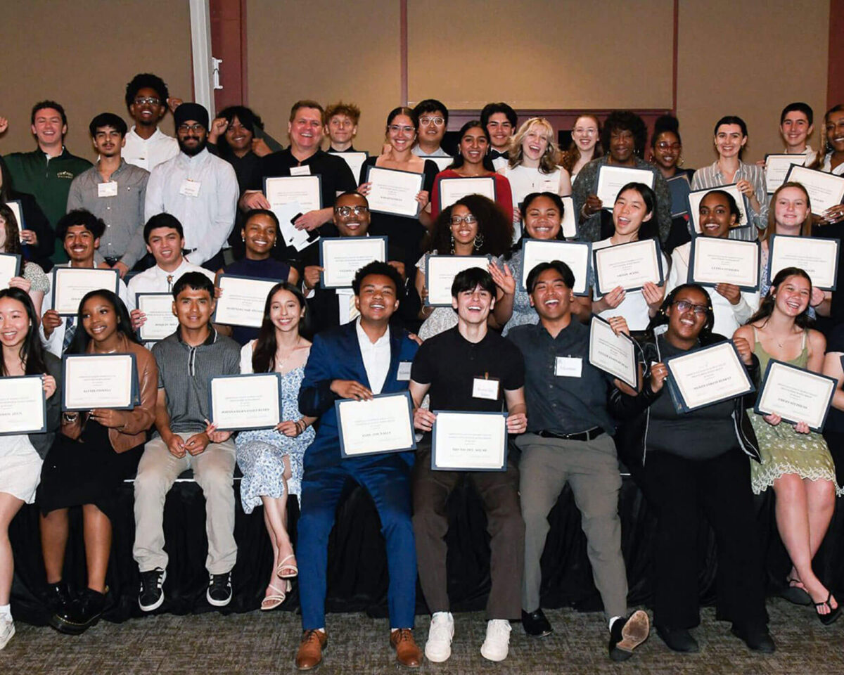 Scholarship recipients smiling and holding their award certificates at a Diablo Valley Giving Partners ceremony