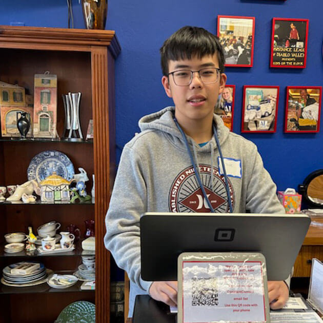 Volunteen helping operate the point-of-sale tablet at the Giving Partners Thrift Shop